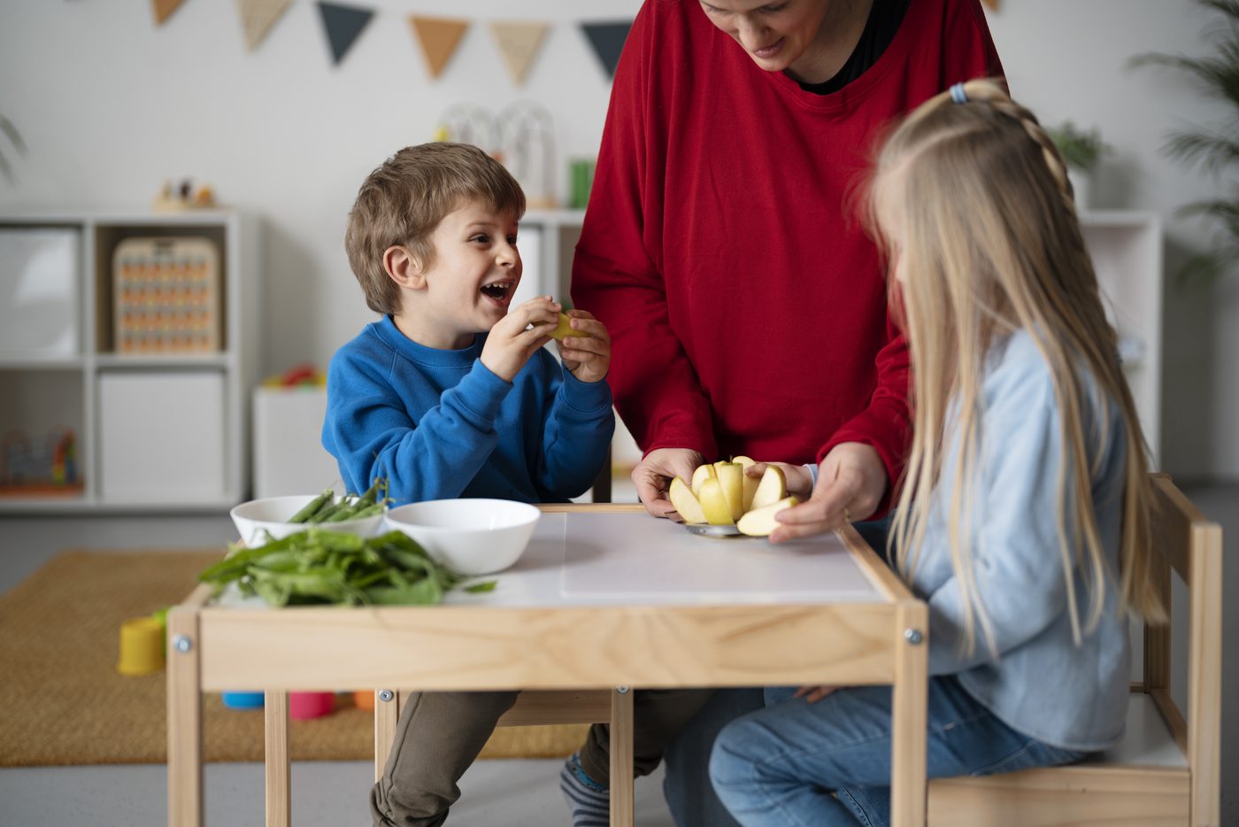 Children watching their teacher slice an apple for snack